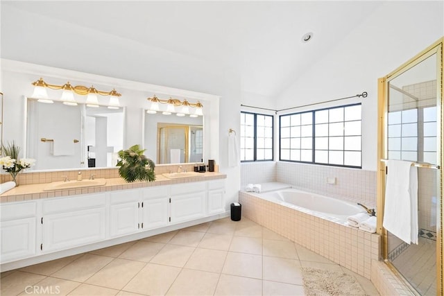 bathroom with tile patterned flooring, a sink, lofted ceiling, and double vanity