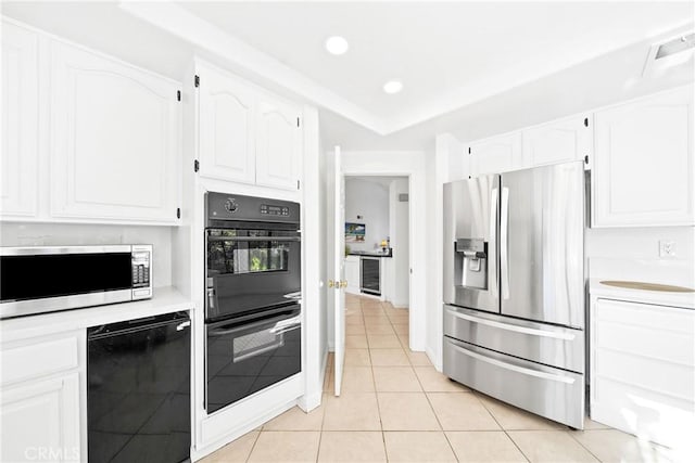 kitchen featuring black appliances, light tile patterned flooring, light countertops, and white cabinets