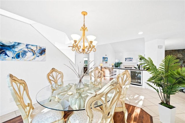 dining room featuring an inviting chandelier, light tile patterned floors, and vaulted ceiling