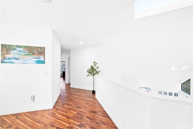 corridor featuring baseboards and wood finished floors