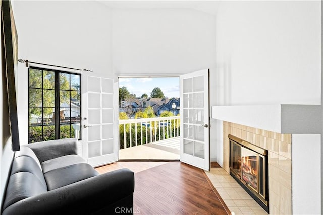 interior space featuring high vaulted ceiling, french doors, a fireplace, and light wood finished floors