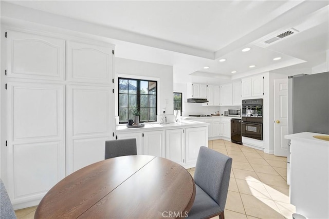 dining area featuring light tile patterned flooring, a raised ceiling, visible vents, and recessed lighting