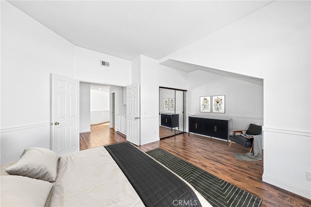 bedroom featuring vaulted ceiling, wood finished floors, and visible vents