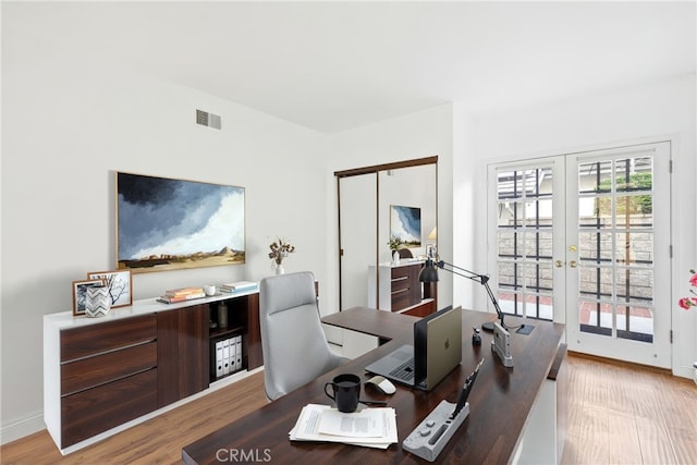 home office featuring baseboards, visible vents, wood finished floors, and french doors