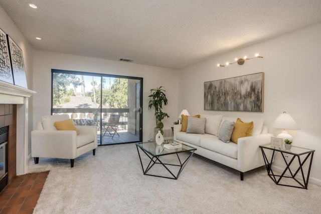 carpeted living room featuring a textured ceiling and a fireplace