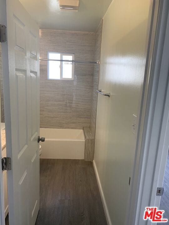 full bathroom with toilet, vanity, tiled shower / bath combo, and hardwood / wood-style flooring