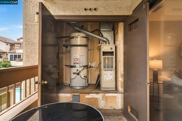 utility room featuring strapped water heater