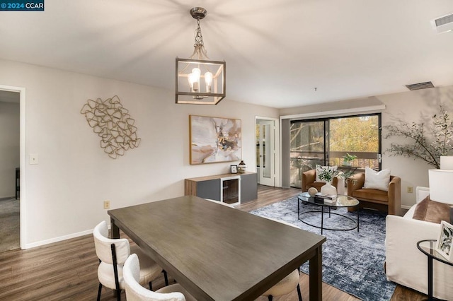 dining area with a notable chandelier and dark hardwood / wood-style flooring