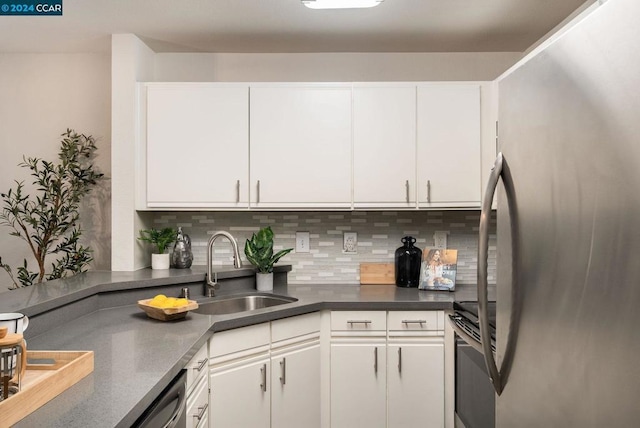 kitchen with tasteful backsplash, white cabinetry, sink, and appliances with stainless steel finishes