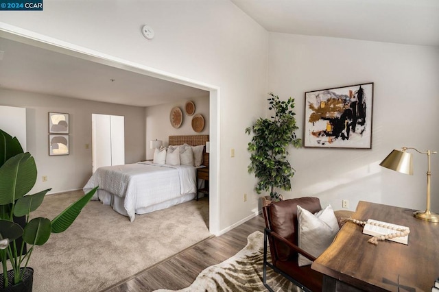 bedroom with vaulted ceiling and hardwood / wood-style flooring