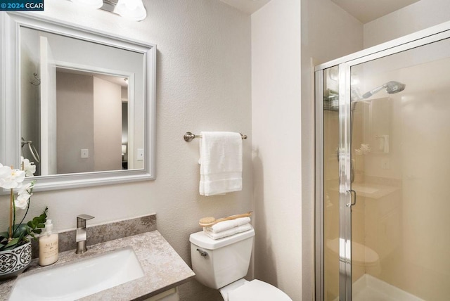 bathroom featuring vanity, toilet, and an enclosed shower