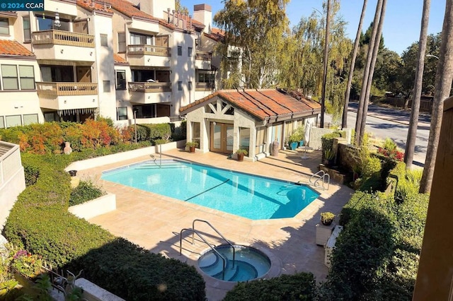 view of pool with a community hot tub and a patio