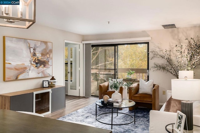 sitting room featuring wood-type flooring and an inviting chandelier