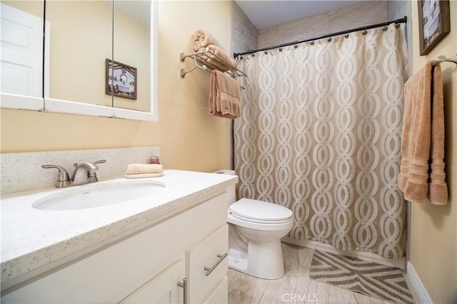 bathroom featuring curtained shower, vanity, and toilet