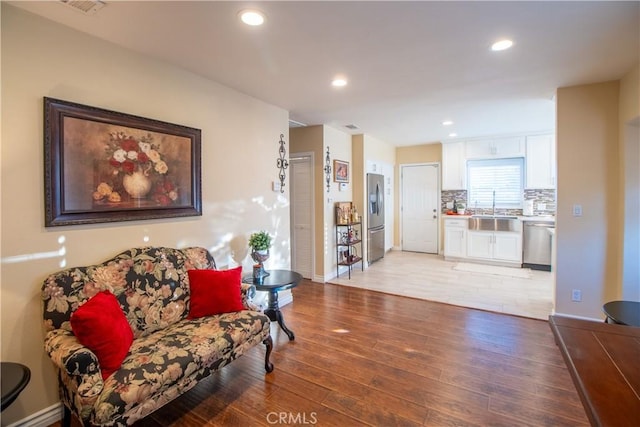 living room with sink and light hardwood / wood-style floors