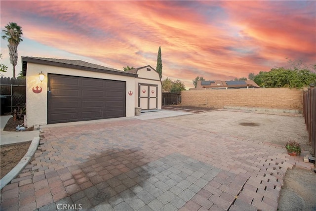 view of garage at dusk