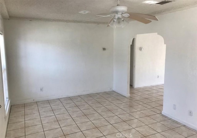 tiled empty room featuring a textured ceiling and ceiling fan