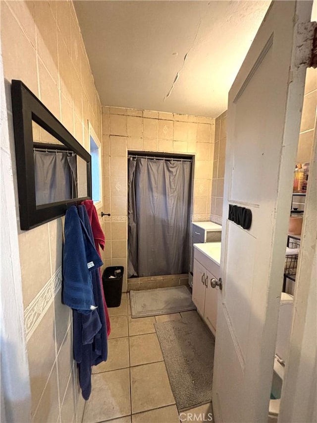 bathroom with tile patterned flooring, vanity, a shower with shower curtain, and tile walls