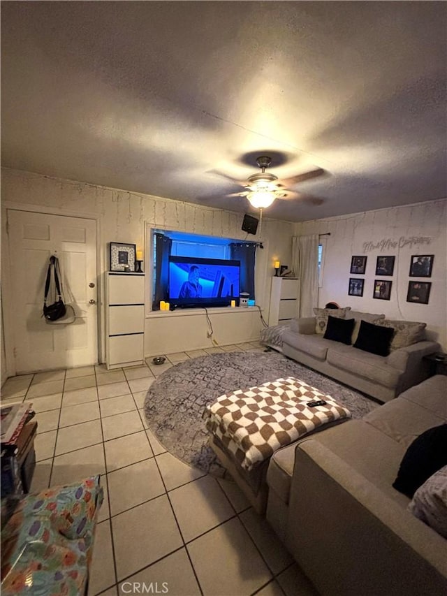 living room with light tile patterned floors, a textured ceiling, and ceiling fan