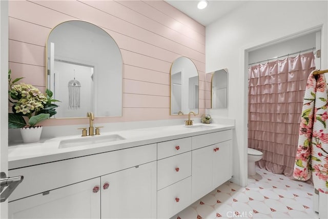 bathroom with curtained shower, wood walls, vanity, and toilet