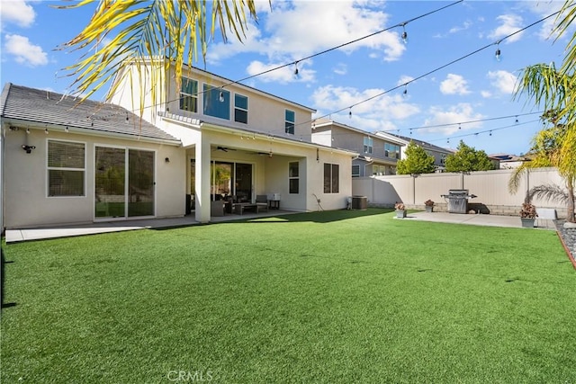 back of property with ceiling fan, a yard, cooling unit, and a patio