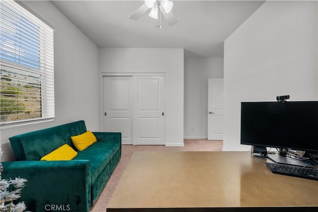 living room featuring ceiling fan and carpet