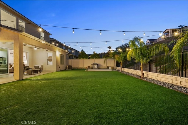 yard at dusk with central AC, ceiling fan, and a patio area