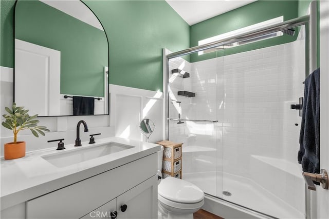 bathroom featuring vanity, toilet, and walk in shower