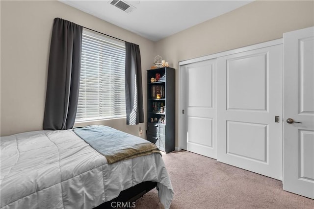 bedroom featuring light carpet and a closet