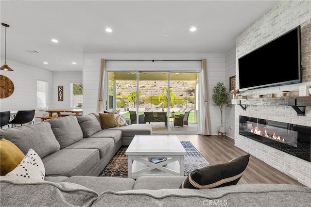 living room with a stone fireplace and wood-type flooring