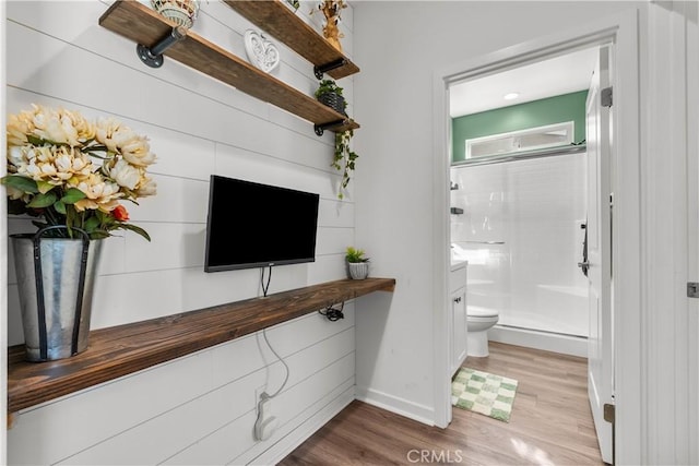 bathroom featuring wood-type flooring, toilet, and an enclosed shower