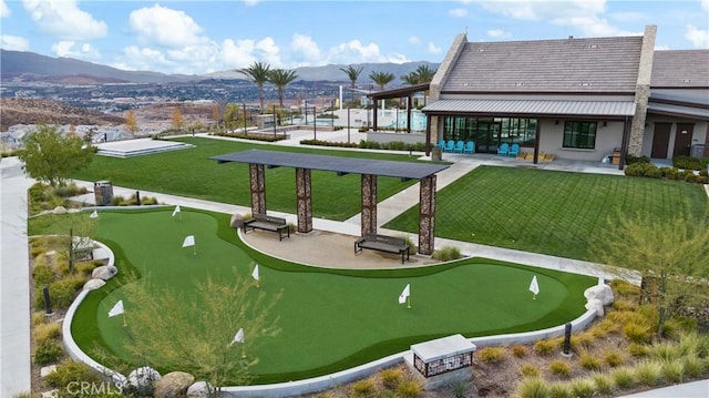 view of property's community with a mountain view, a yard, and a patio