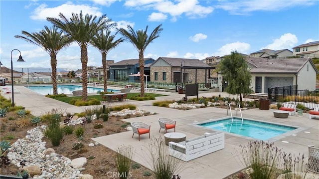 view of pool with a community hot tub and a patio