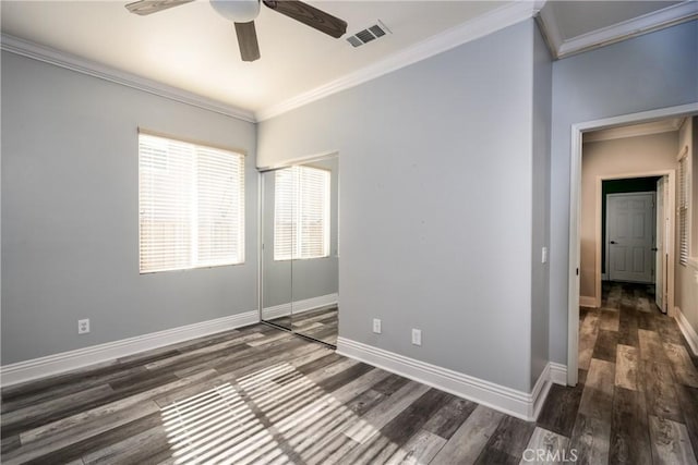 spare room with crown molding, ceiling fan, and dark wood-type flooring