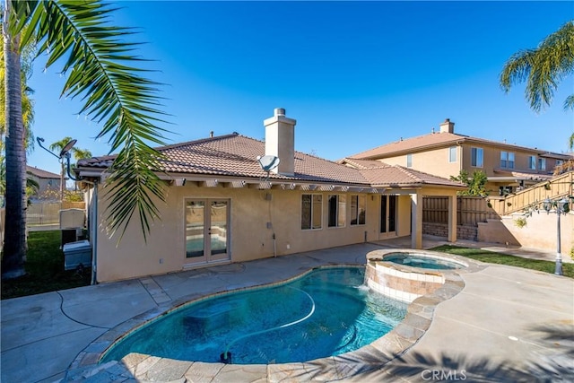 view of swimming pool with a patio area, an in ground hot tub, and french doors