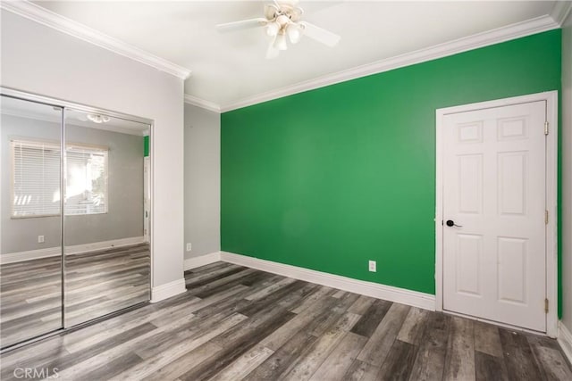 unfurnished bedroom with hardwood / wood-style floors, a closet, ceiling fan, and crown molding