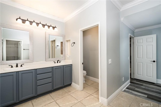 bathroom with tile patterned floors, crown molding, vanity, and toilet