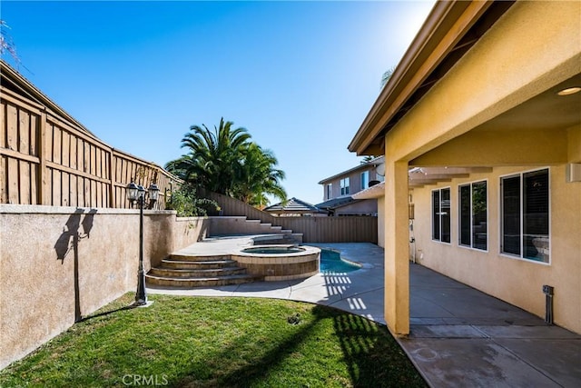 view of yard featuring an in ground hot tub and a patio