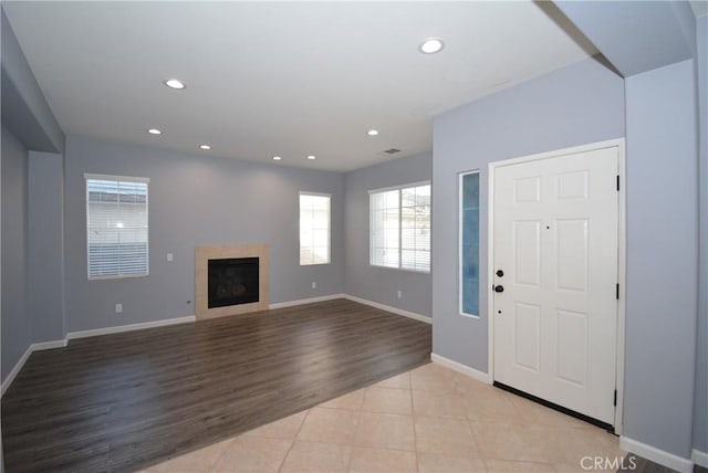 foyer featuring a tile fireplace and light wood-type flooring