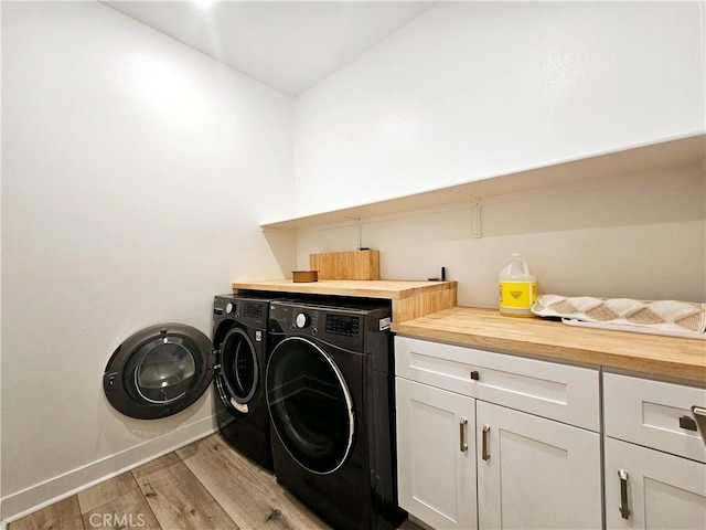 washroom with light hardwood / wood-style floors, cabinets, and independent washer and dryer