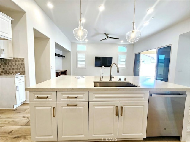 kitchen with sink, hanging light fixtures, dishwasher, and backsplash