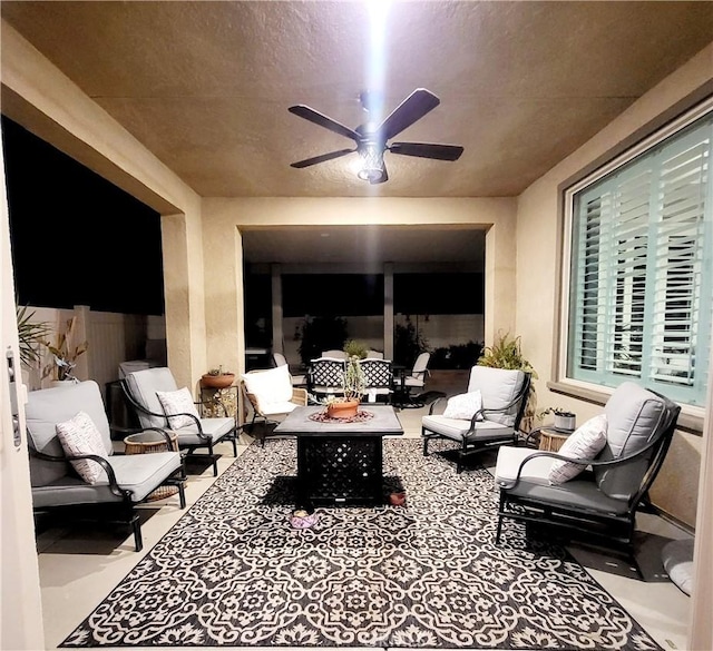 view of patio / terrace with an outdoor living space with a fire pit and ceiling fan