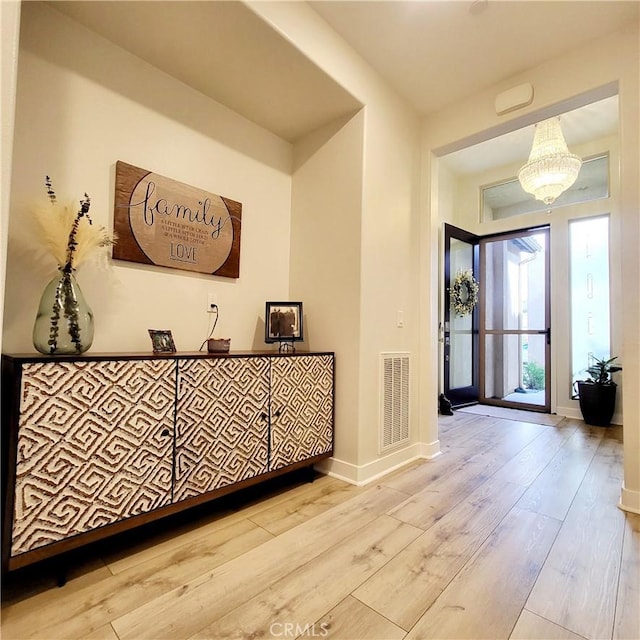 foyer featuring a notable chandelier and light hardwood / wood-style flooring