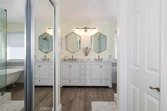 bathroom with a bath, wood-type flooring, and vanity