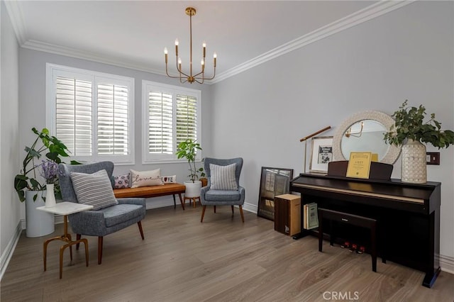 sitting room with hardwood / wood-style flooring, crown molding, and a chandelier