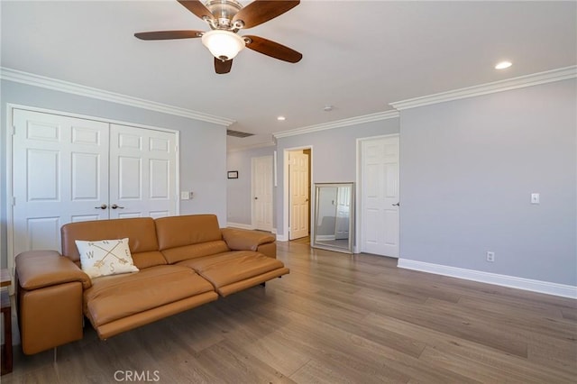 living room with hardwood / wood-style floors, ceiling fan, and crown molding