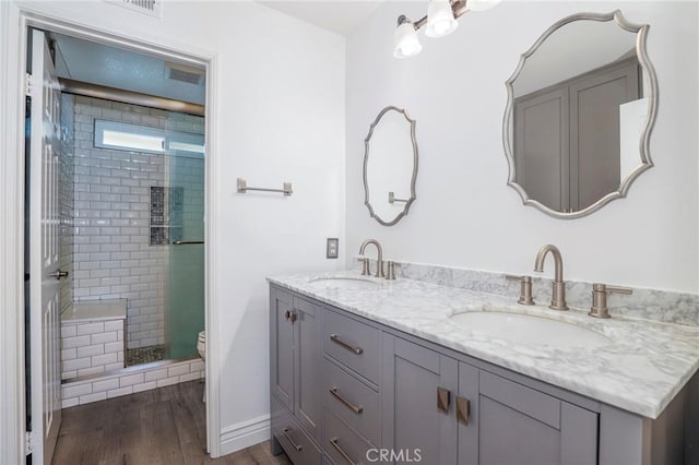 bathroom with a shower with door, vanity, wood-type flooring, and toilet