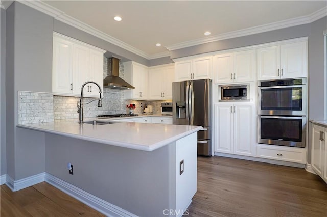 kitchen featuring stainless steel appliances, white cabinetry, dark hardwood / wood-style floors, and wall chimney range hood