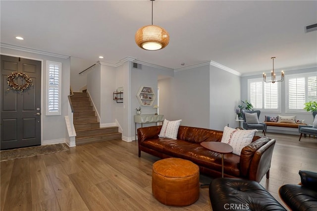 living room featuring an inviting chandelier, light hardwood / wood-style floors, and ornamental molding