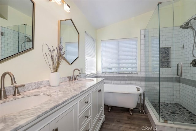 bathroom with vanity, independent shower and bath, lofted ceiling, and hardwood / wood-style flooring